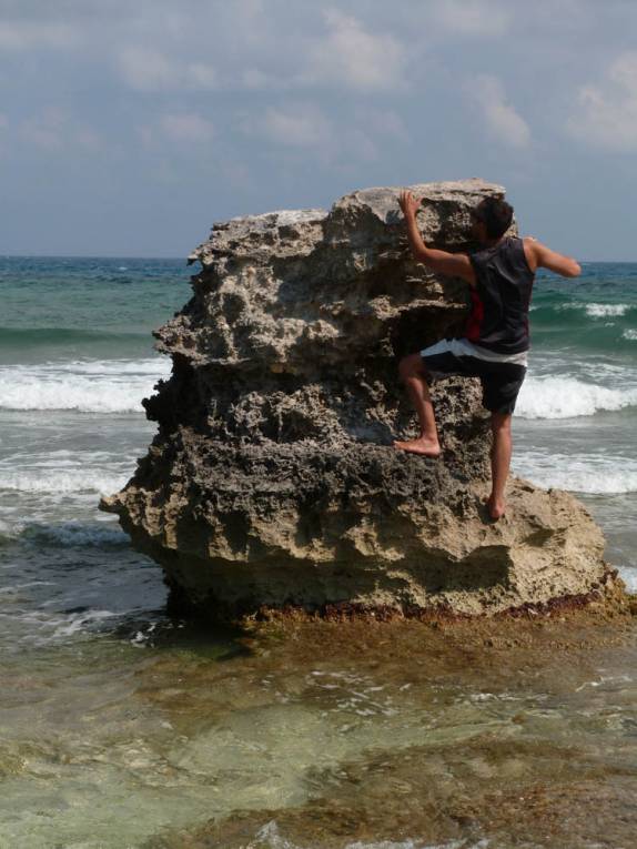 Escalando pequeno rochedo em praia da Isla Mujeres, na costa caribenha no sul do México